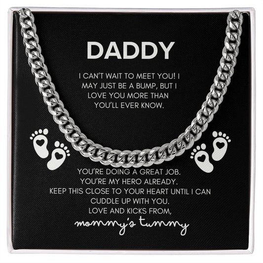 a message card that reads Daddy I can't wait to meet you! I may be just a bump, but I love you already more than you'll ever know. you're doing a great job. you're my hero already. keep this close to your heart until I can cuddle up WITH you.  love and Kicks from, Mommy's Tummy including a STAINLESS  Cuban link chain and baby feet in a STANDARD gift box.